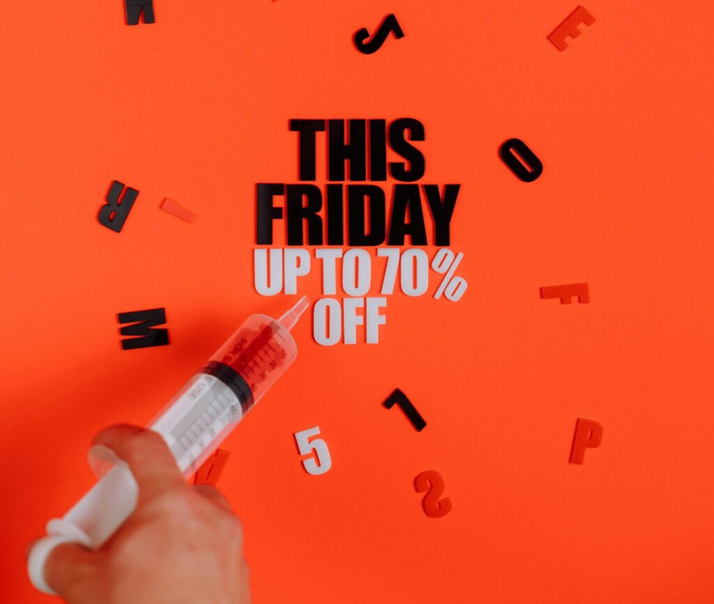 Vibrant Black Friday sale concept featuring a syringe and bold typography on red background.